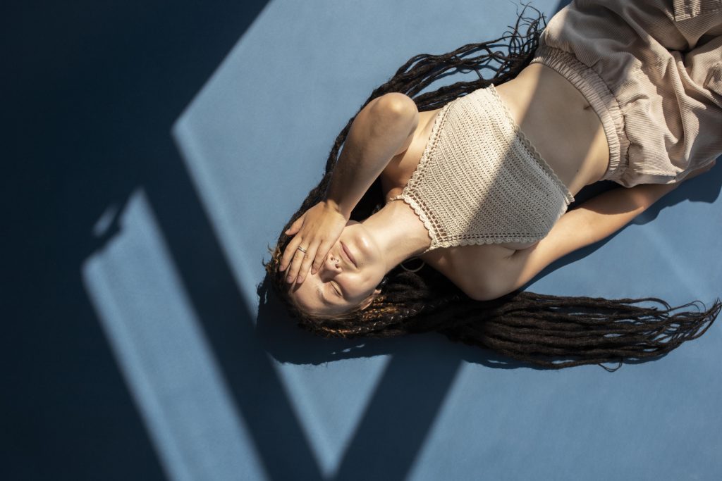 fille-vue-de-dessus-avec-des-dreadlocks-allongee-sur-le-sol